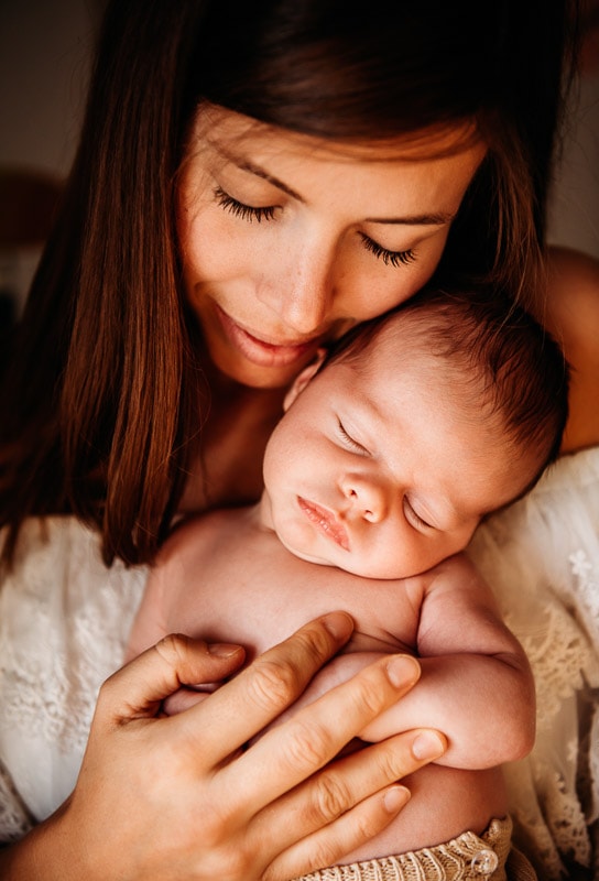 mum holding newborn close to her face for newborn photographer west sussex in Horsham