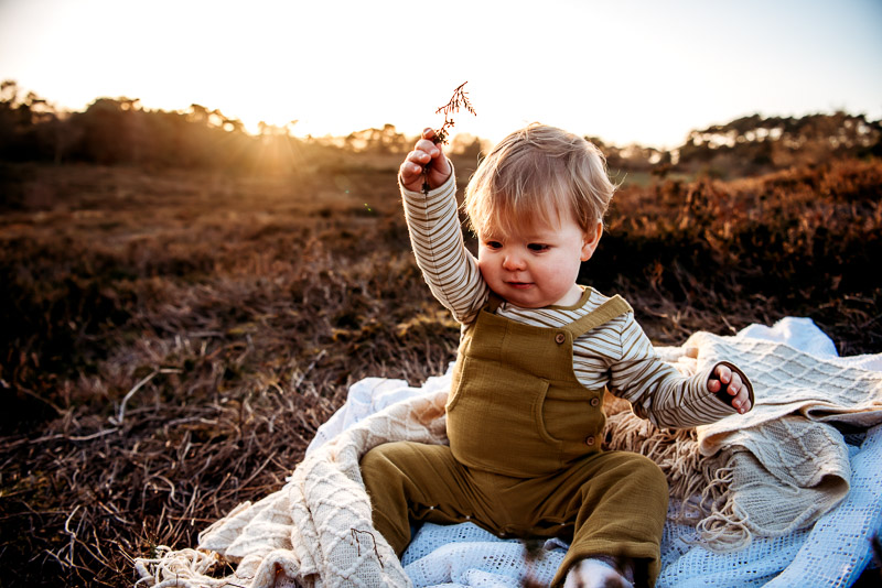 baby sitting and playing on the floor during childrens portrait session