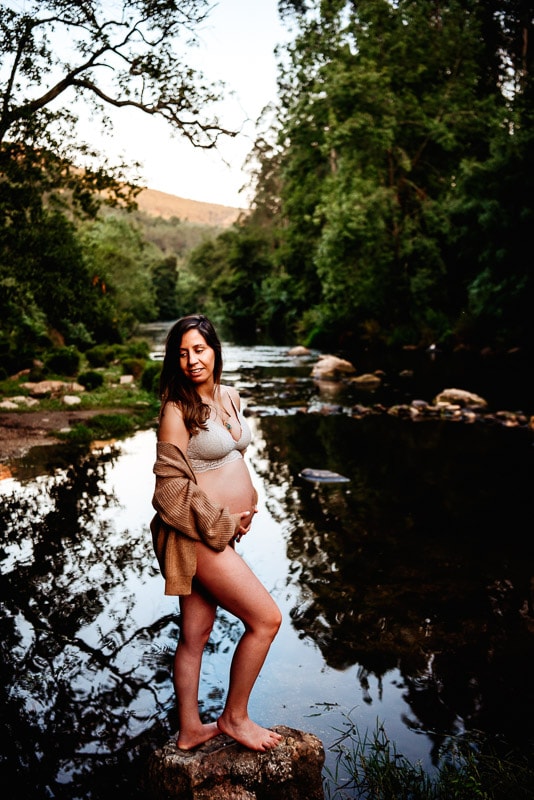 pregnant woman posing in front of river with maternity photography session