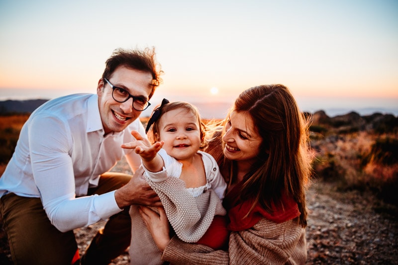 Parents and small child posing for west sussex family photographer