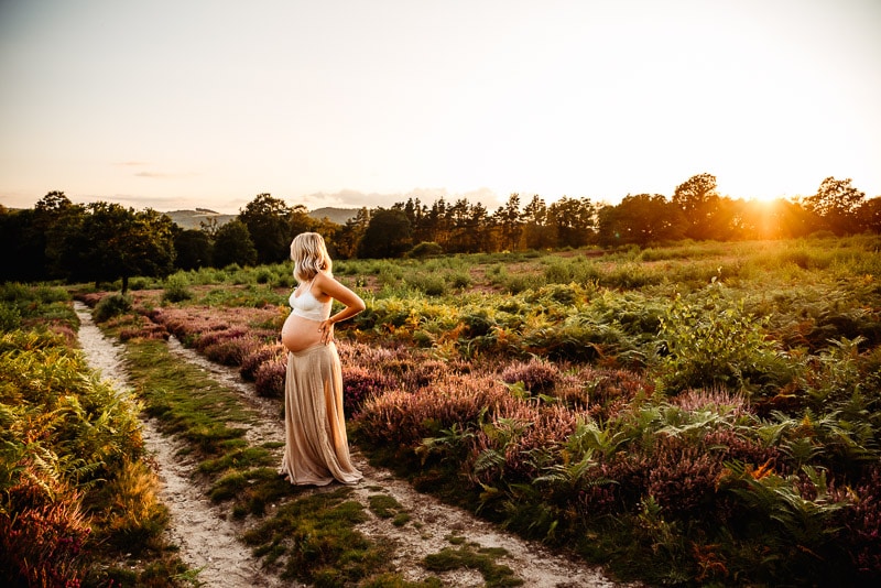 pregnant woman looking at horizon during sunset pregnancy photography session