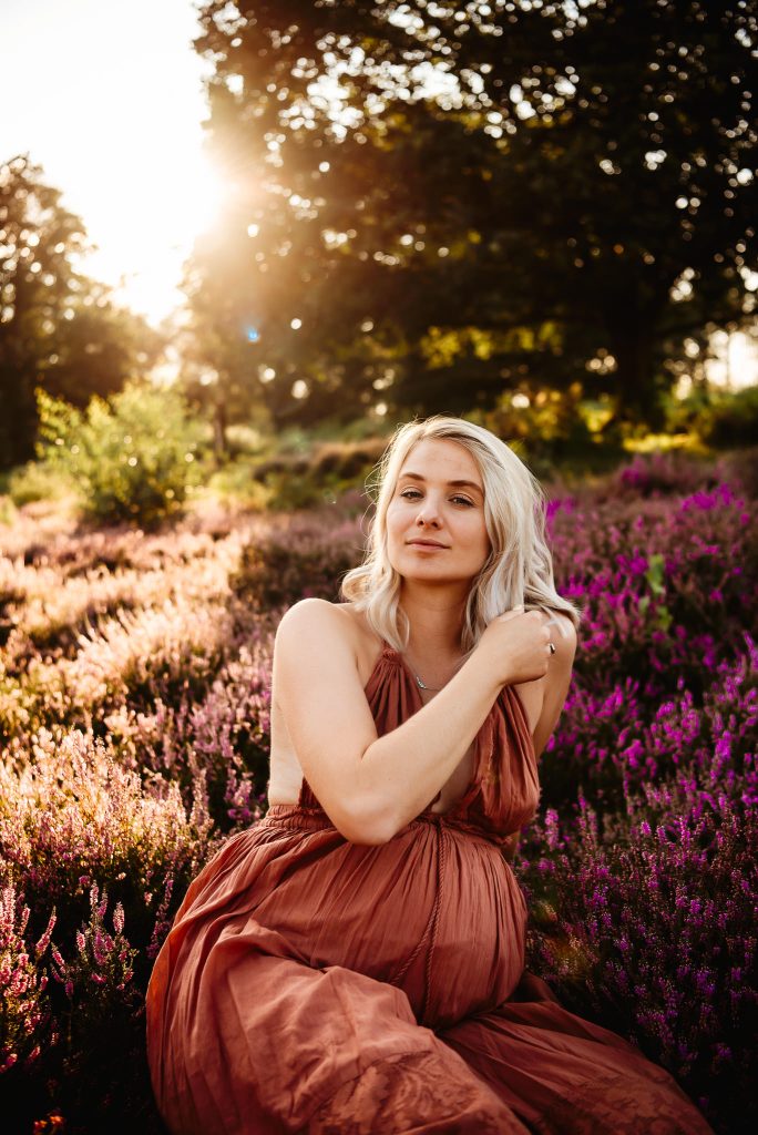 Women expecting and looking at camera during golden hour photography session in Pulborough, West Sussex