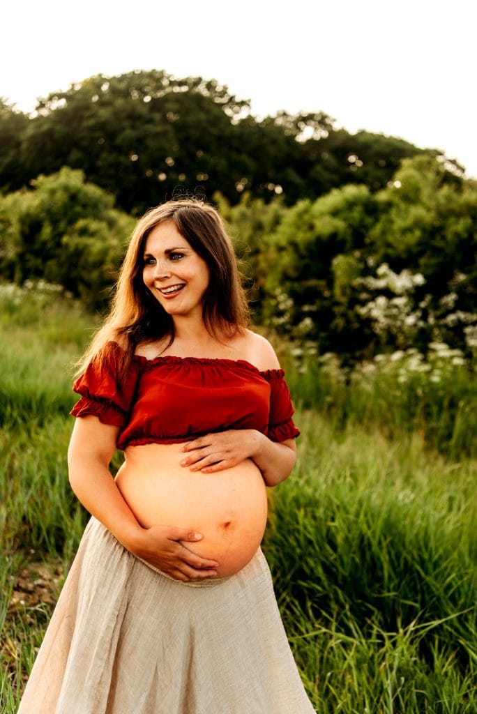 Pregnant woman looking to the side while holding her belly 