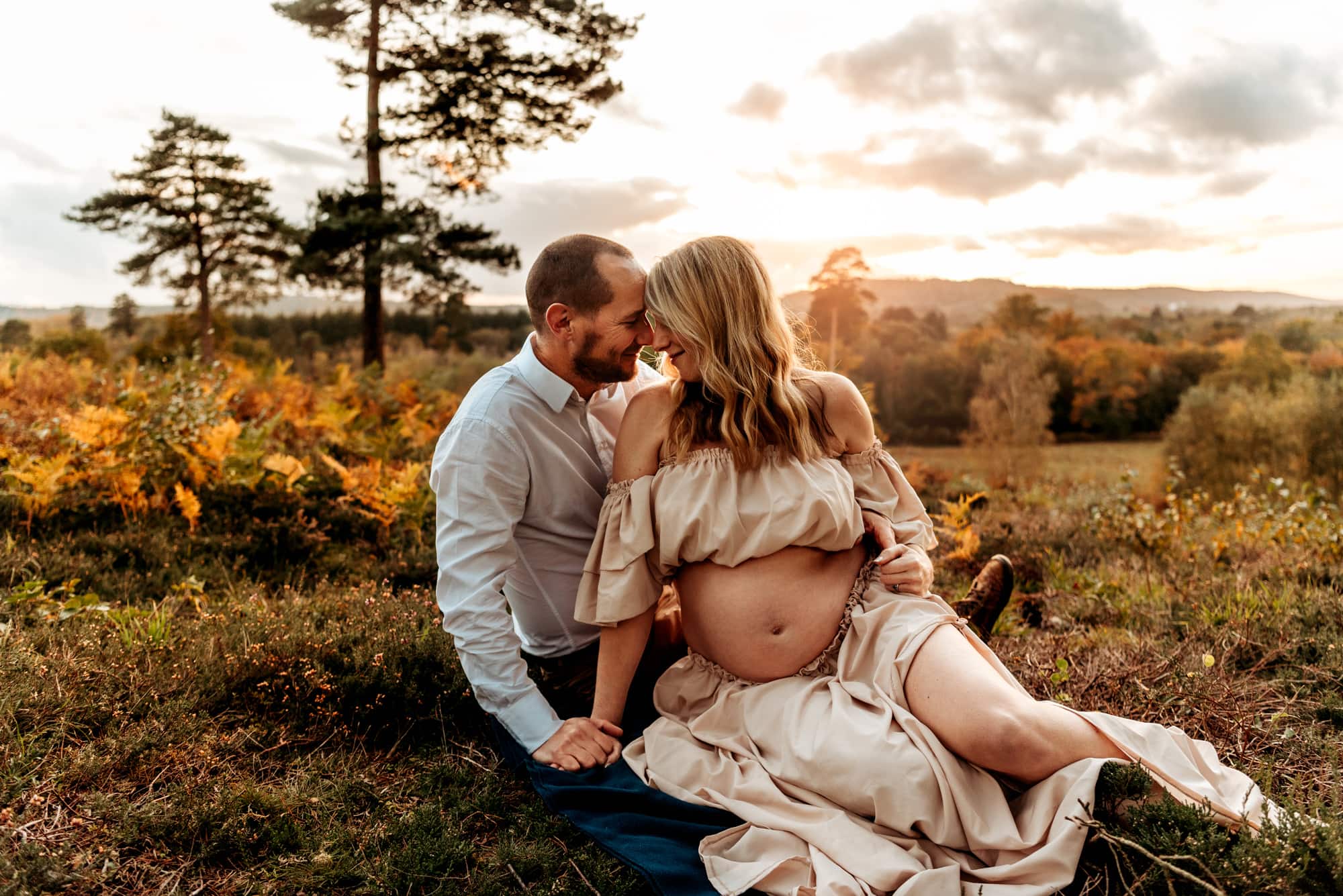 couple sitting on the floor with heads together enjoying sunset