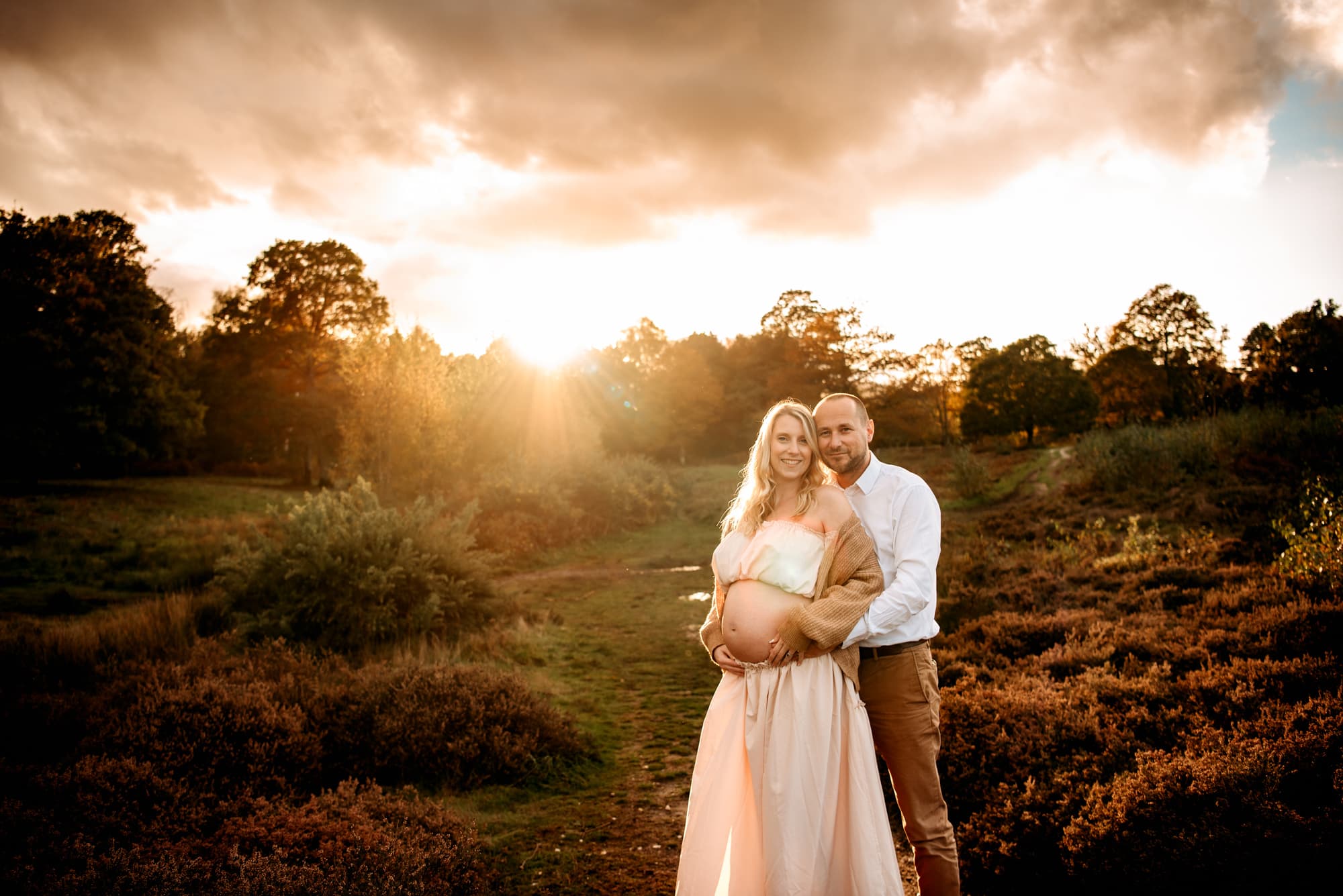 Couple posing to photograph at sunset