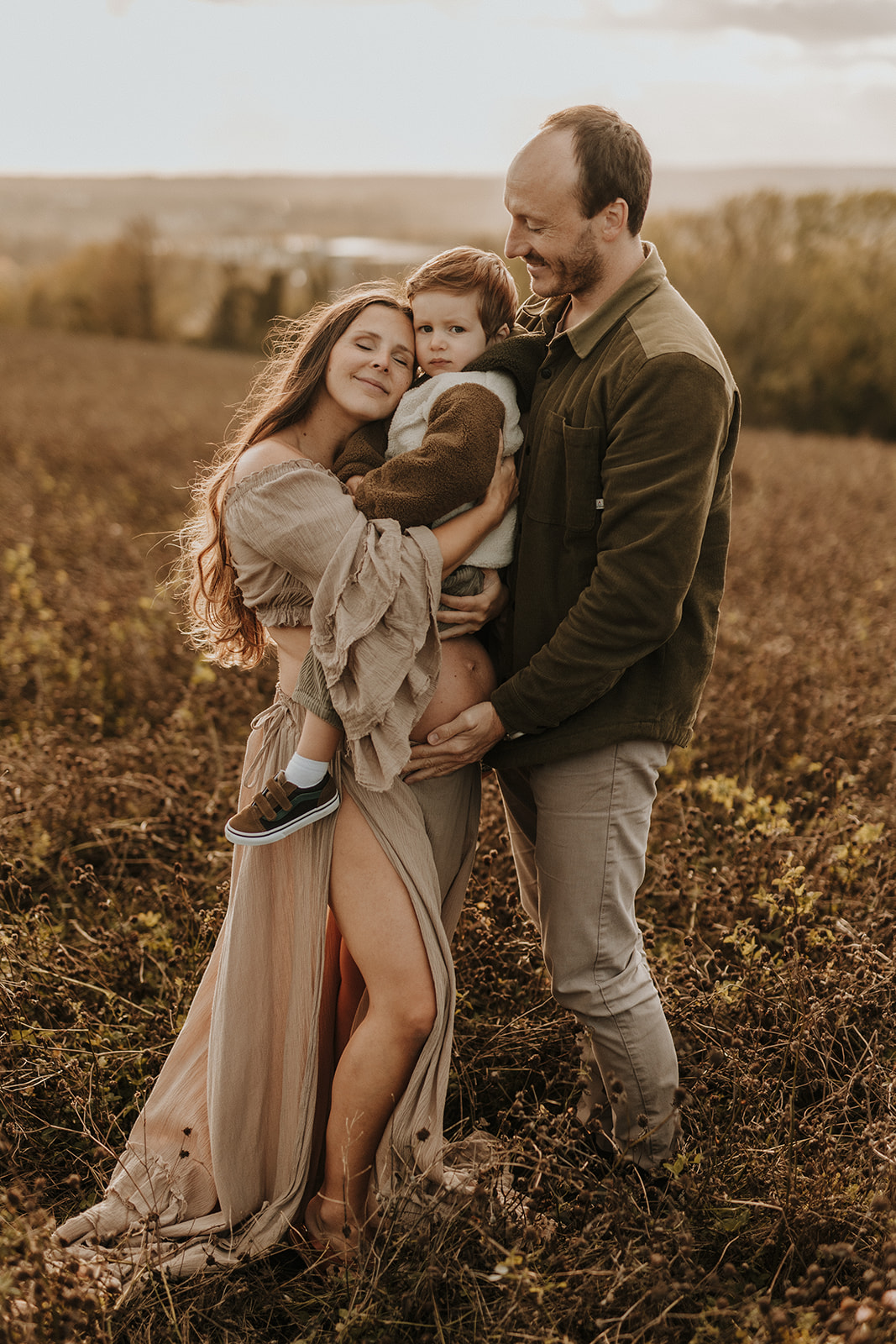 Family posing and embracing each others with eyes closed and smilling at sunset, South East photographer