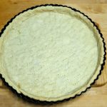 Vorgebackener Quicheteig in einer Quicheform nach dem einfachen Grundrezept für eine Quiche