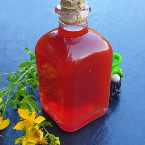 Eine kleine Glasflasche mit Johanniskrautöl, auch Rotöl genannt