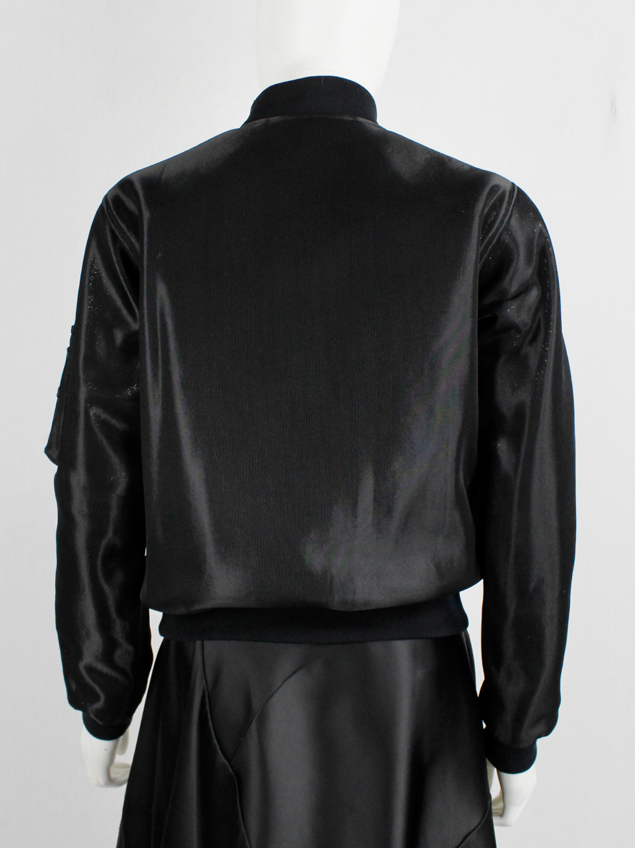 Noir Kei Ninomiya black bomber jacket with belted strap across the 