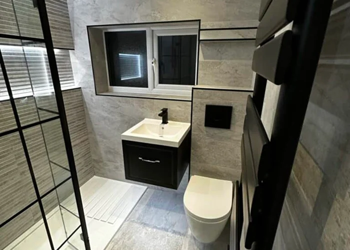 Modern bathroom installation with vanity unit, mirror and walk-in shower screen