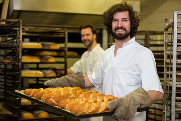 smiling-baker-carrying-tray-freshly-baked-french-baguette smiling-baker-carrying-tray-freshly-baked-french-baguette