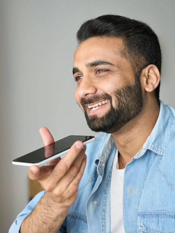 young-indian-man-speaking-to-voice-assistant-using-smartphone-.jpg