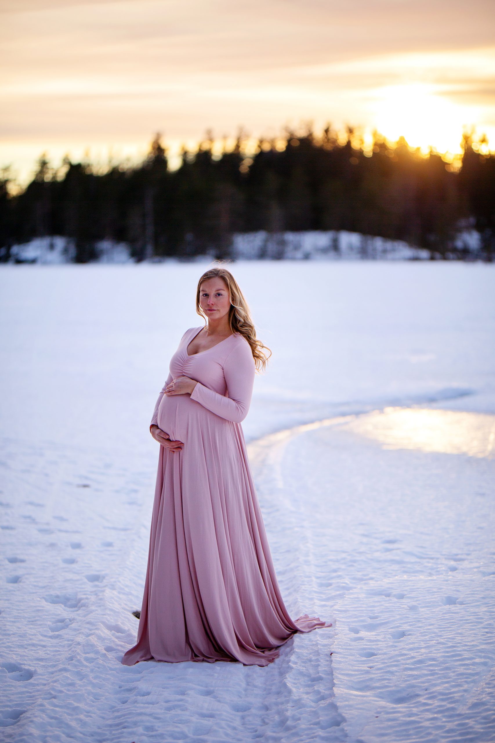 Gravidfotografering på isen i solnedgång.