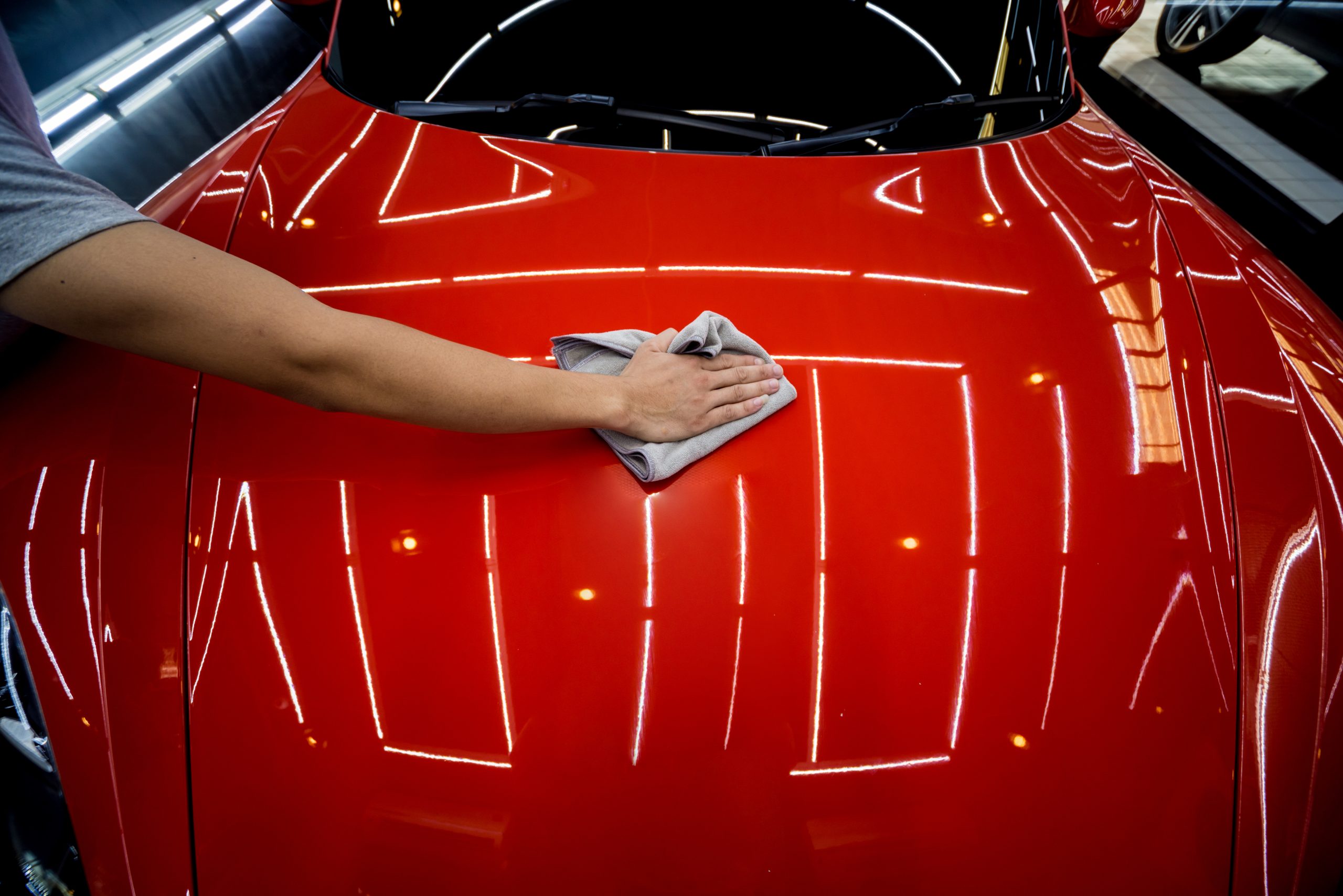 Car service worker applying nano coating on a car detail