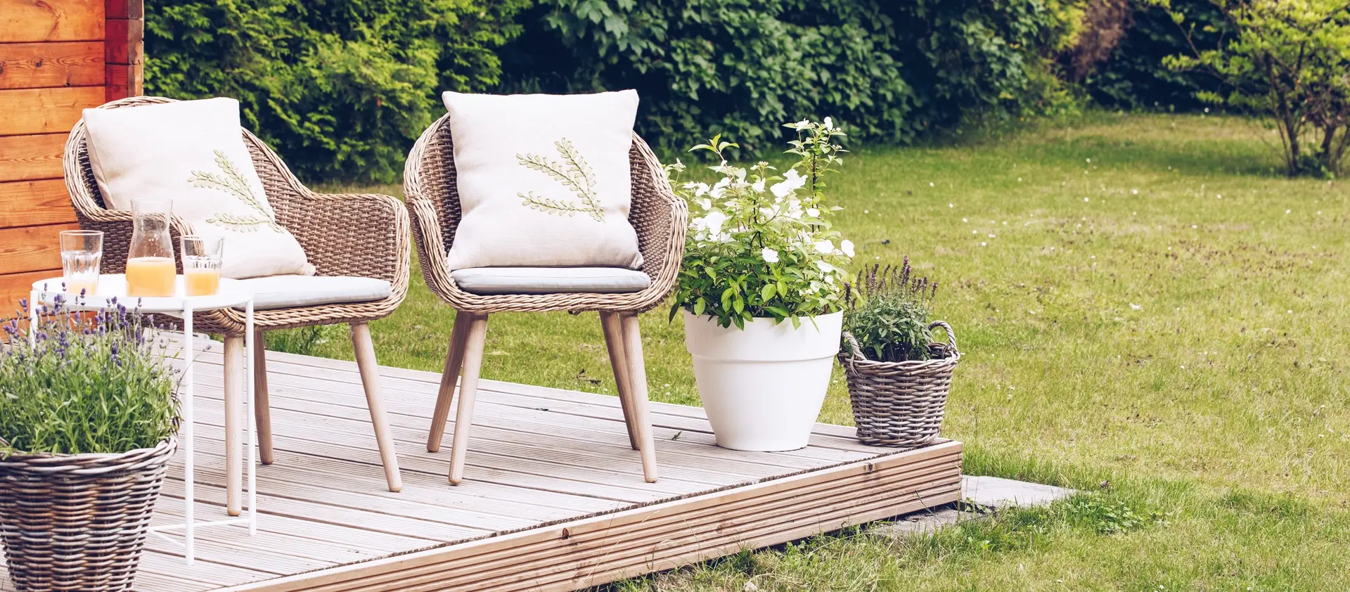 trall en härlig sommardag med korgstolar och blomkrukor på trallgolv
