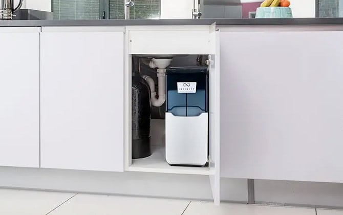 Image shows the Infinity water softener sits within a kitchen unit.