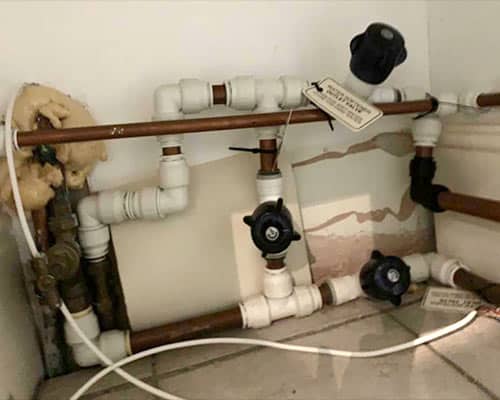 This image shows how an old water softener was installed, with an over use of joints, taps and loose cabling.