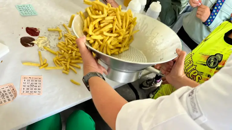 Friet wordt uitgeserveerd op tafel.