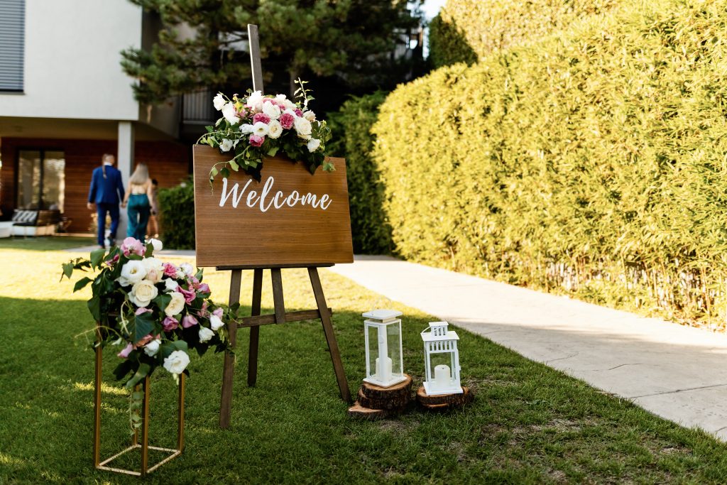 Welcome board at outdoor wedding venue.