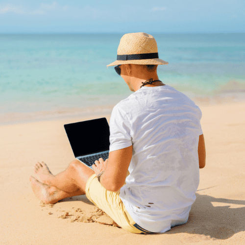 En manlig virtuell assistent arbetar ifrån stranden