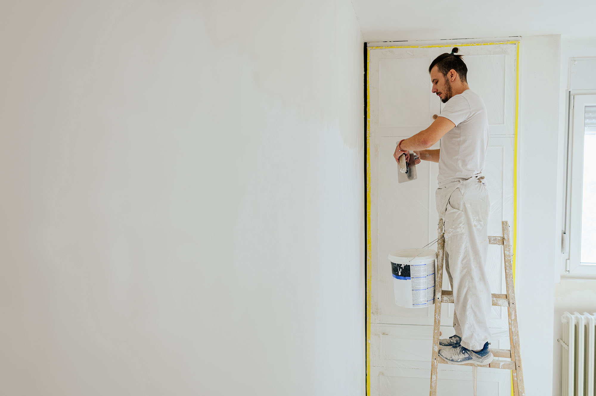 Maler beim Spachteln, Neugründer, EPU, Einpersonenunternehmen, Malerbetrieb, Malerunternehmen, Malerunternehmer, Handwerker bei der Arbeit