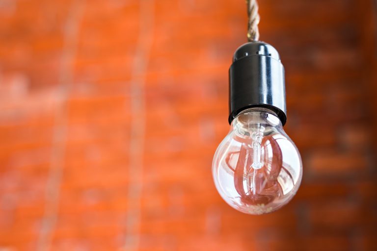 Incandescent lamp on a brick wall background