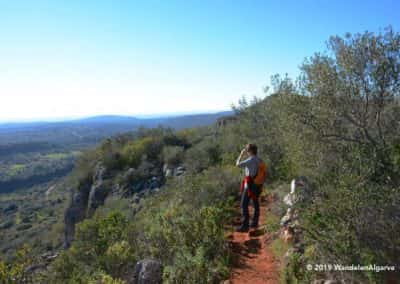 Wandelaar op de rotswand van Rocha da Pena, wandelroute Loulé
