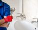 plumber with wrench standing in bathroom