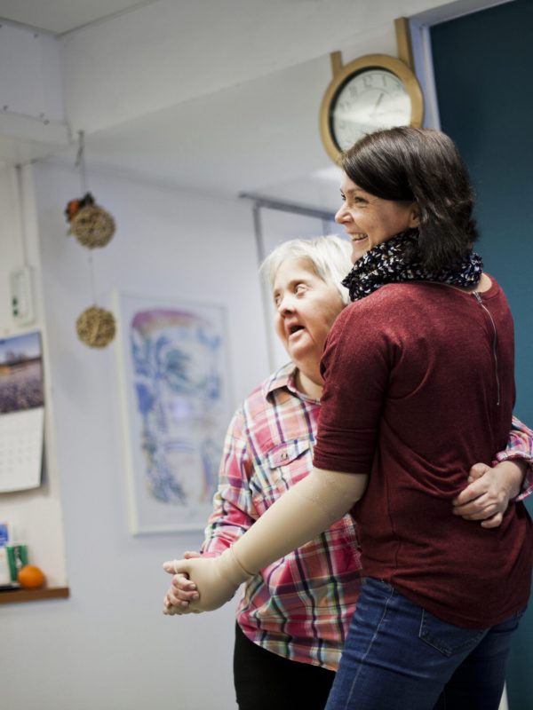 Mentally challenged woman dancing with caregiver at home