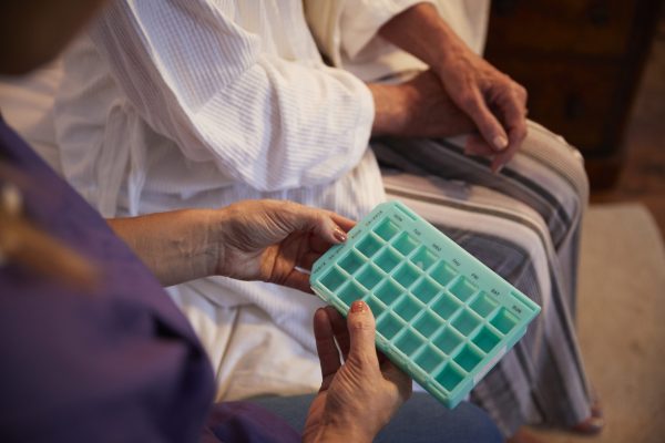 Nurse Helping Senior Woman To Organize Medication On Home Visit