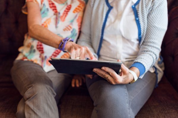 Two women using digital tablet