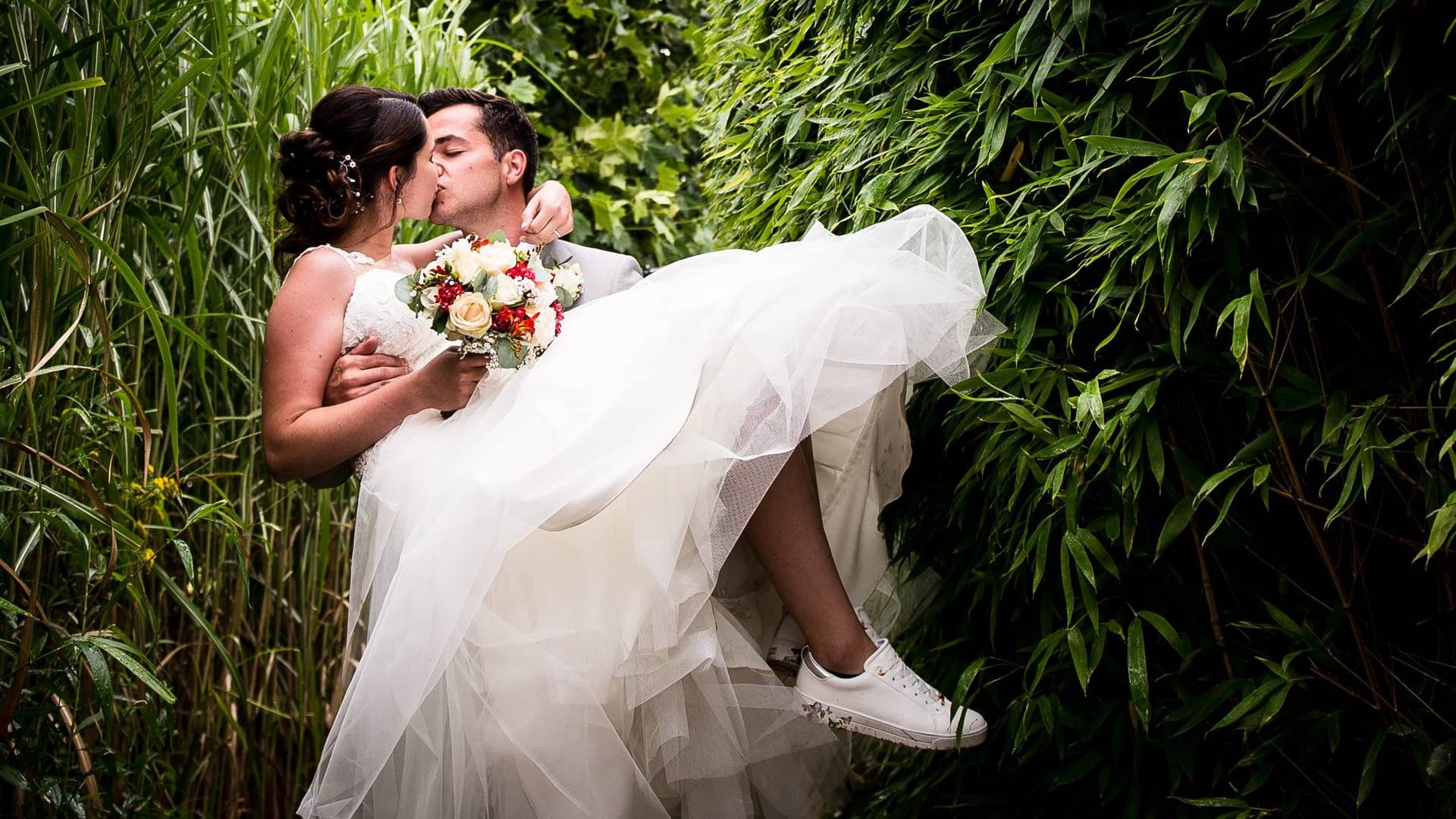 Huwelijksfotoshoot met koppel, bruidegom draagt bruid, trouwfotograaf