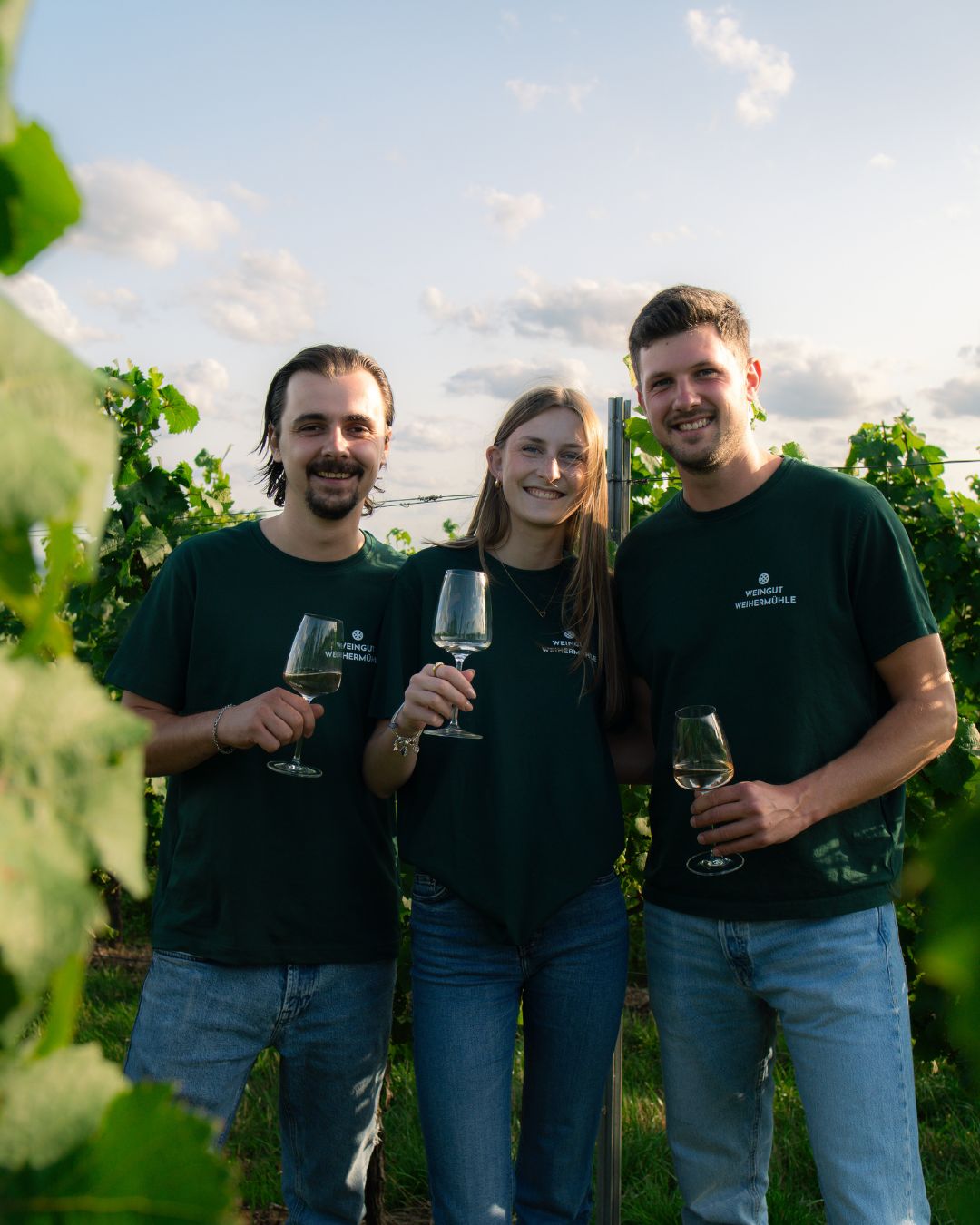 Tamara, Max und Niclas Jung als Jung Nachwuchs zu dritt in den Weinbergen mit Weingläsern in der Hand