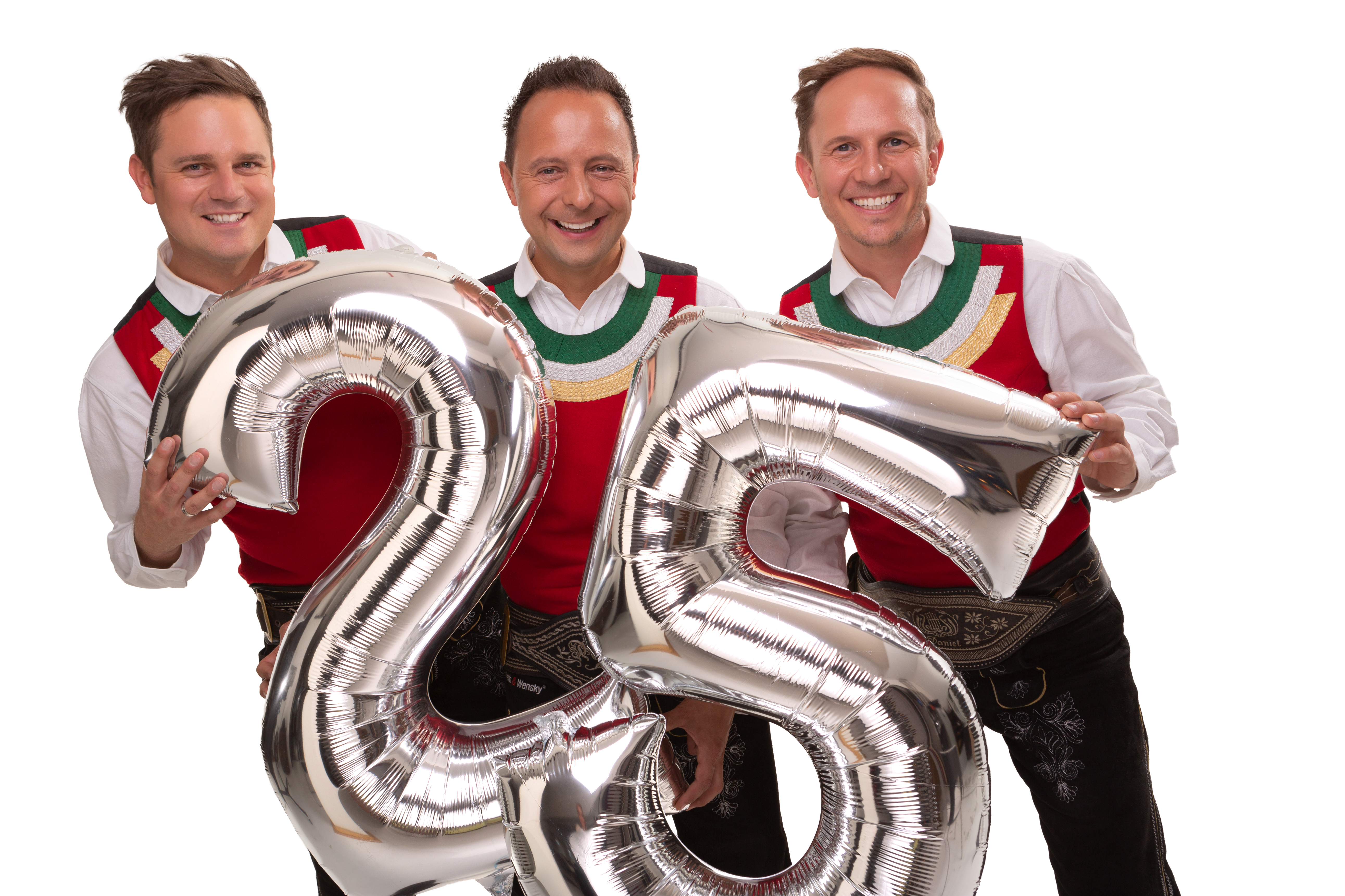 Die jungen Zillertaler feiern Jubiläum, Michael, Markus und Daniel mit einem Luftballon und den Zahlen 2 und 5.