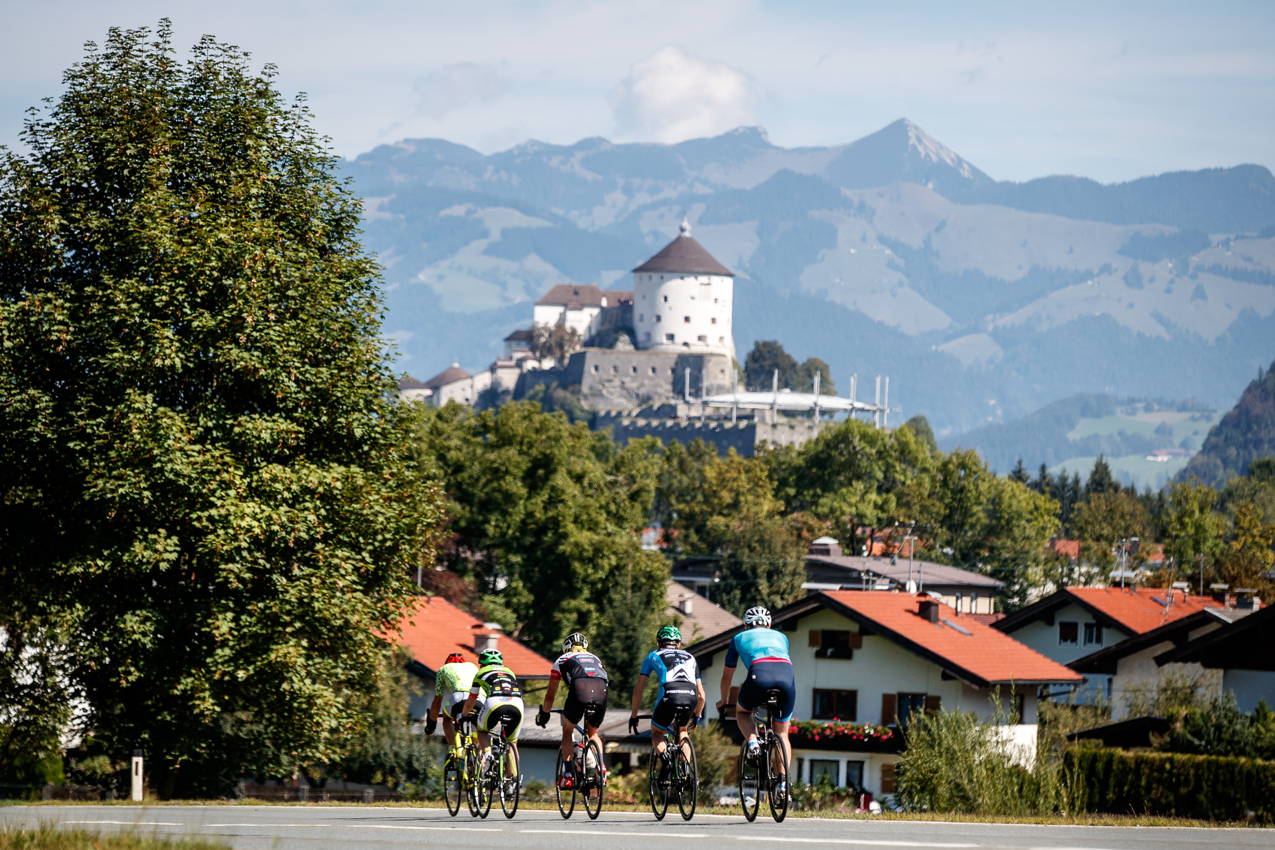 Tour of Austria im Kufsteinerland. Bild zeigt fünf Radfahrer in Kufstein. Im Hintergrund die Festung Kufstein.