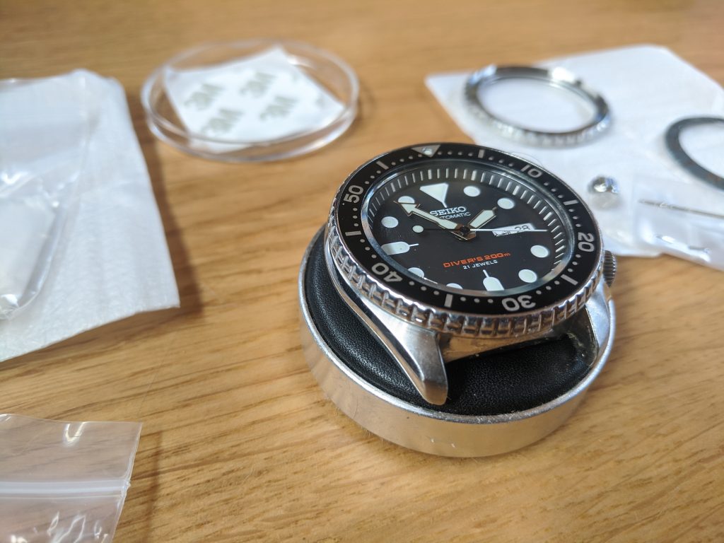 Seiko SKX007J displayed on a watchmakers cushion surrounded by parts ready to modify. Seiko Mods wellingtime 