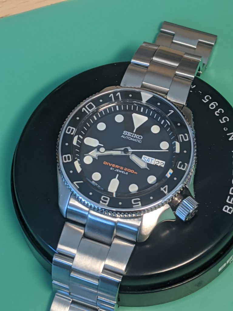 Seiko SKX00J - Steel Coin - Coin Edge Bezel to match the crown with a dual time cermic insert. Displated on a watchmakers cushion on an antistatic matt.