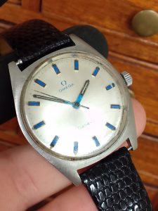 Vintage watch repair - Automatic Inhouse calibre - Omega with aftermarket blue lume on the dial  - displated infront of some watchmakers drawers. 