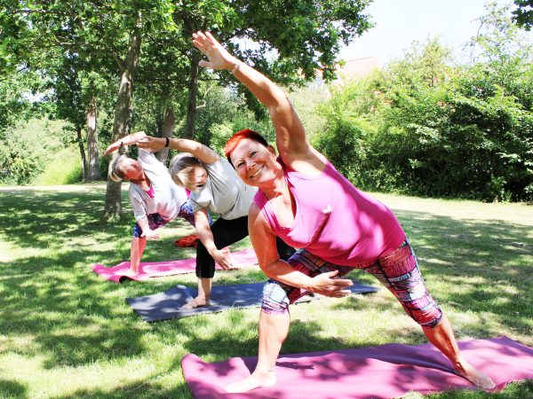 Tre yogier laver blid yoga i museumshaven på Willumsens Museum