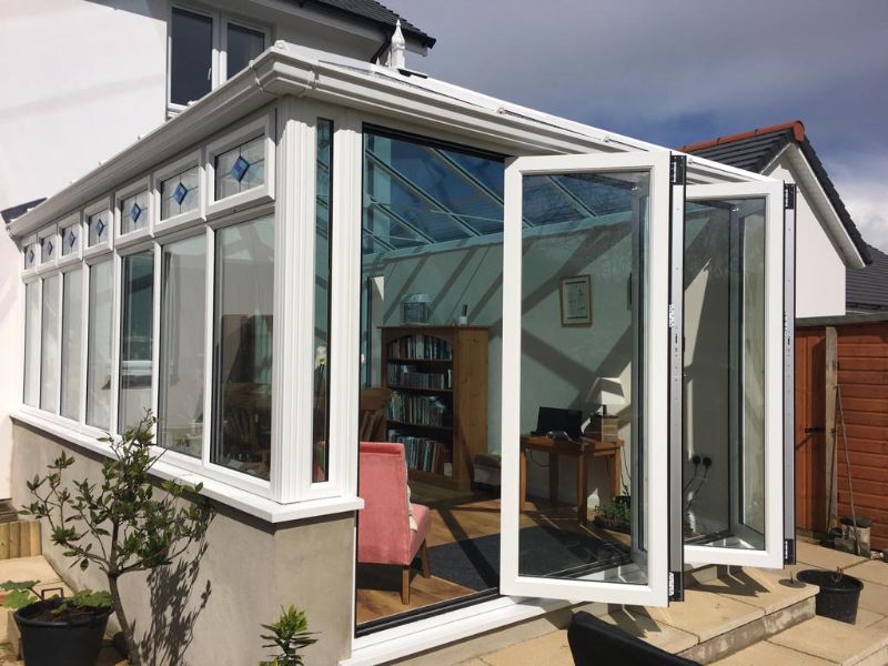 a modern style conservatory with bi-fold doors