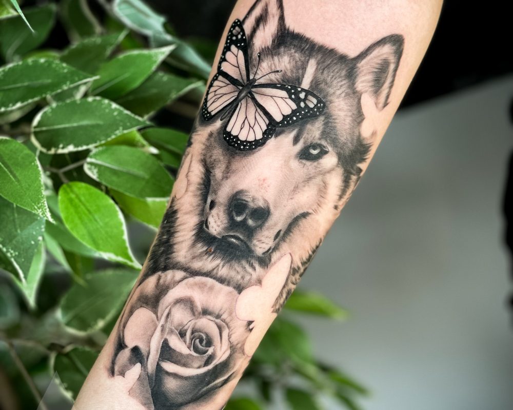 Realistic wolf rose and butterfly tattoo arm piece