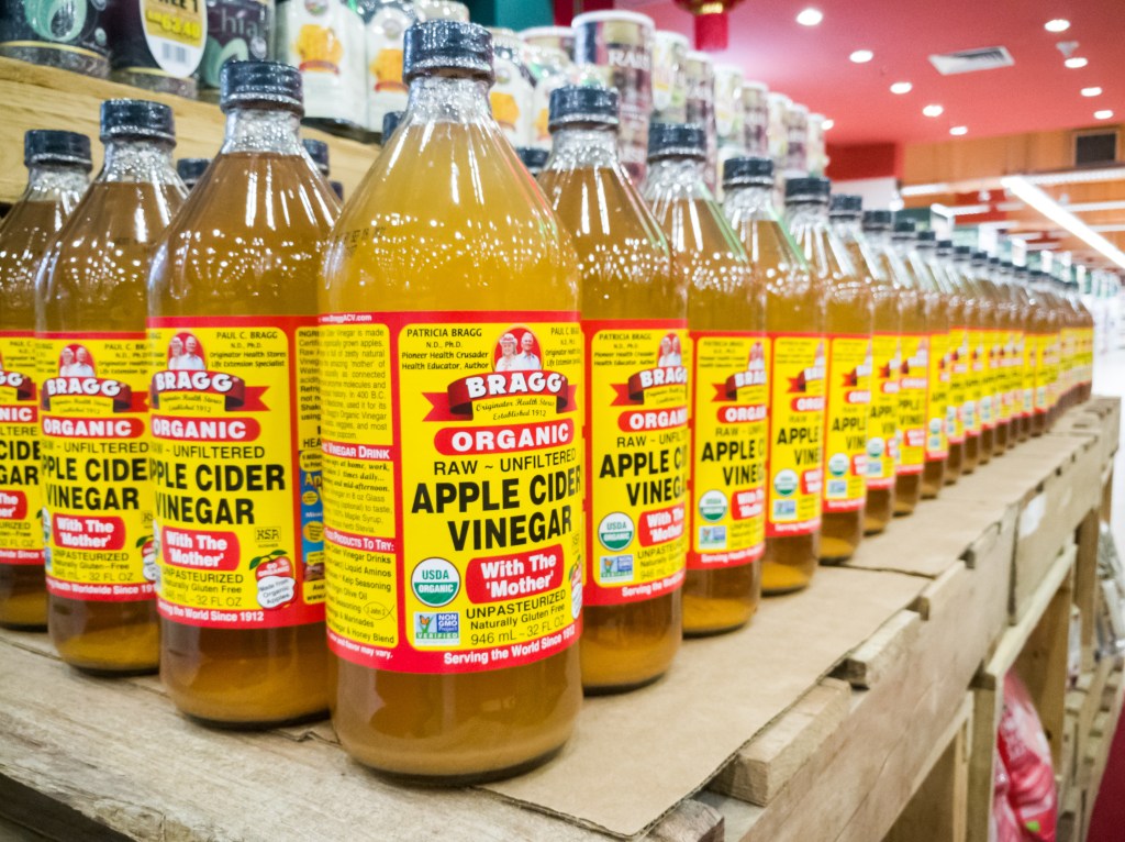 A row of Bragg Organic Apple Cider Vinegar bottles on a shelf in Kuala Lumpur, Malaysia