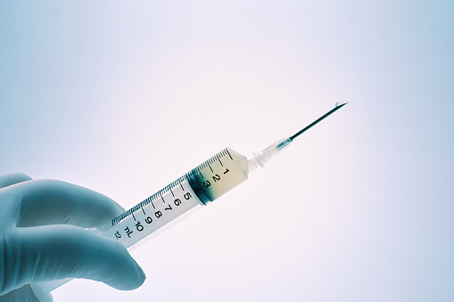 Close-up of doctor's hand with syringe