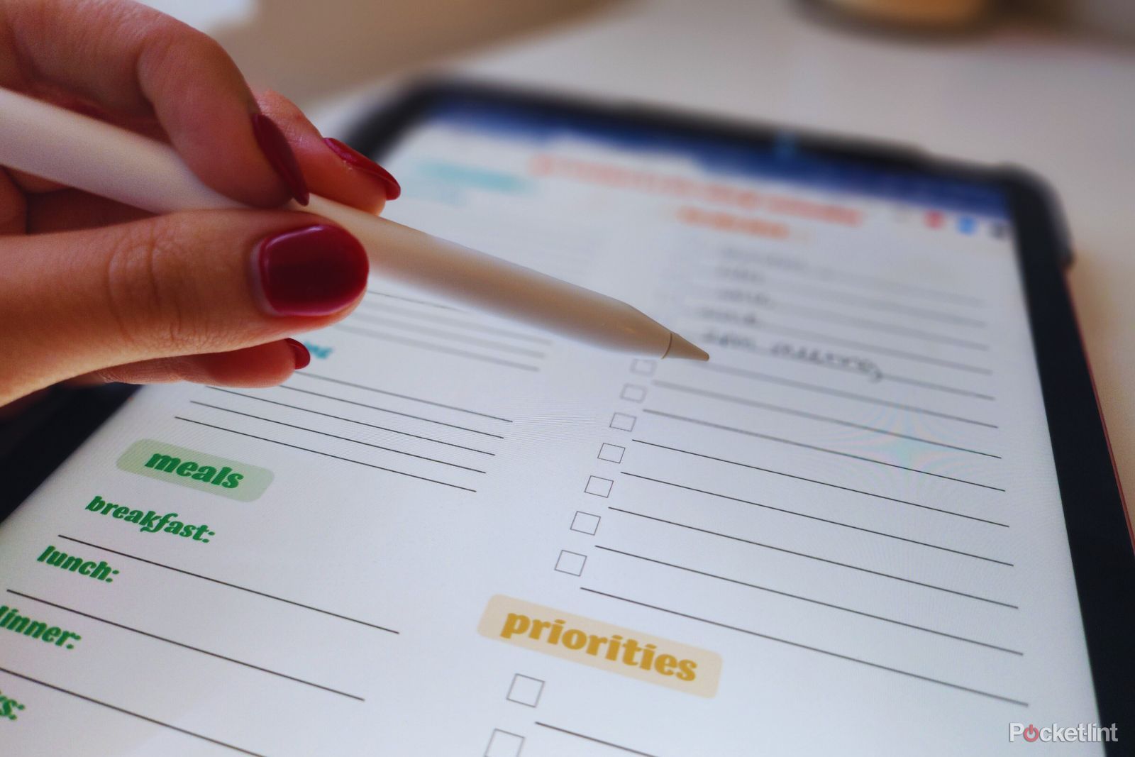 Photo of hand with stylus checking off to do list on iPad