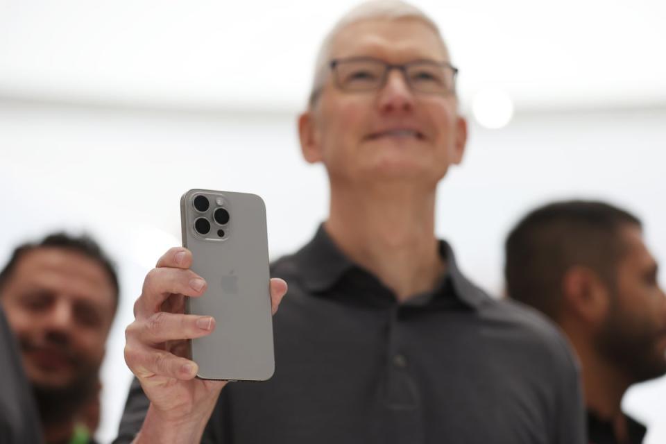 Apple CEO Tim Cook holds up a new iPhone 15 Pro (Getty)