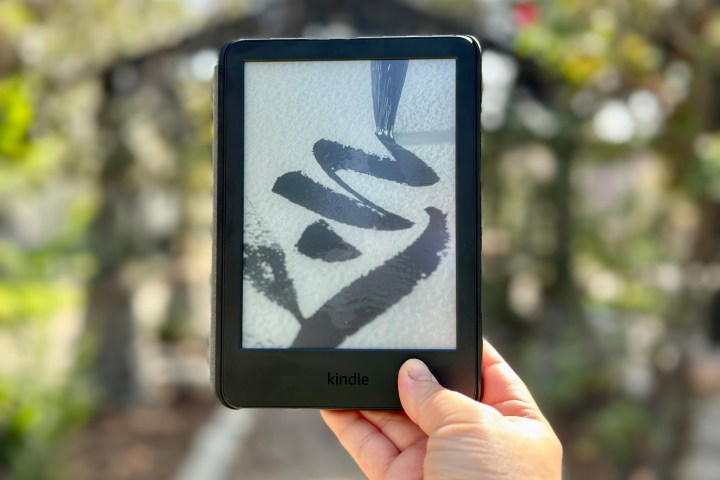 A person holding the Amazon Kindle (2022) outside.