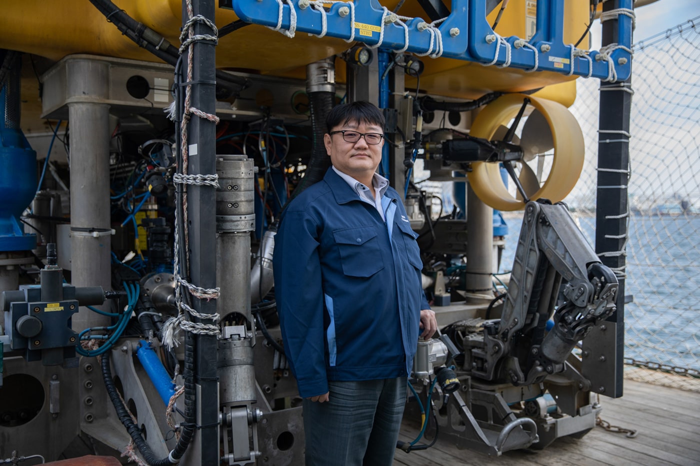 Fumihide Kobayashi standing in front of the submersible Marcas.