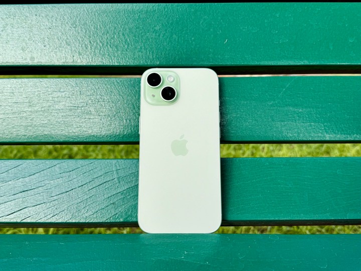 A green iPhone 15 on a green bench.