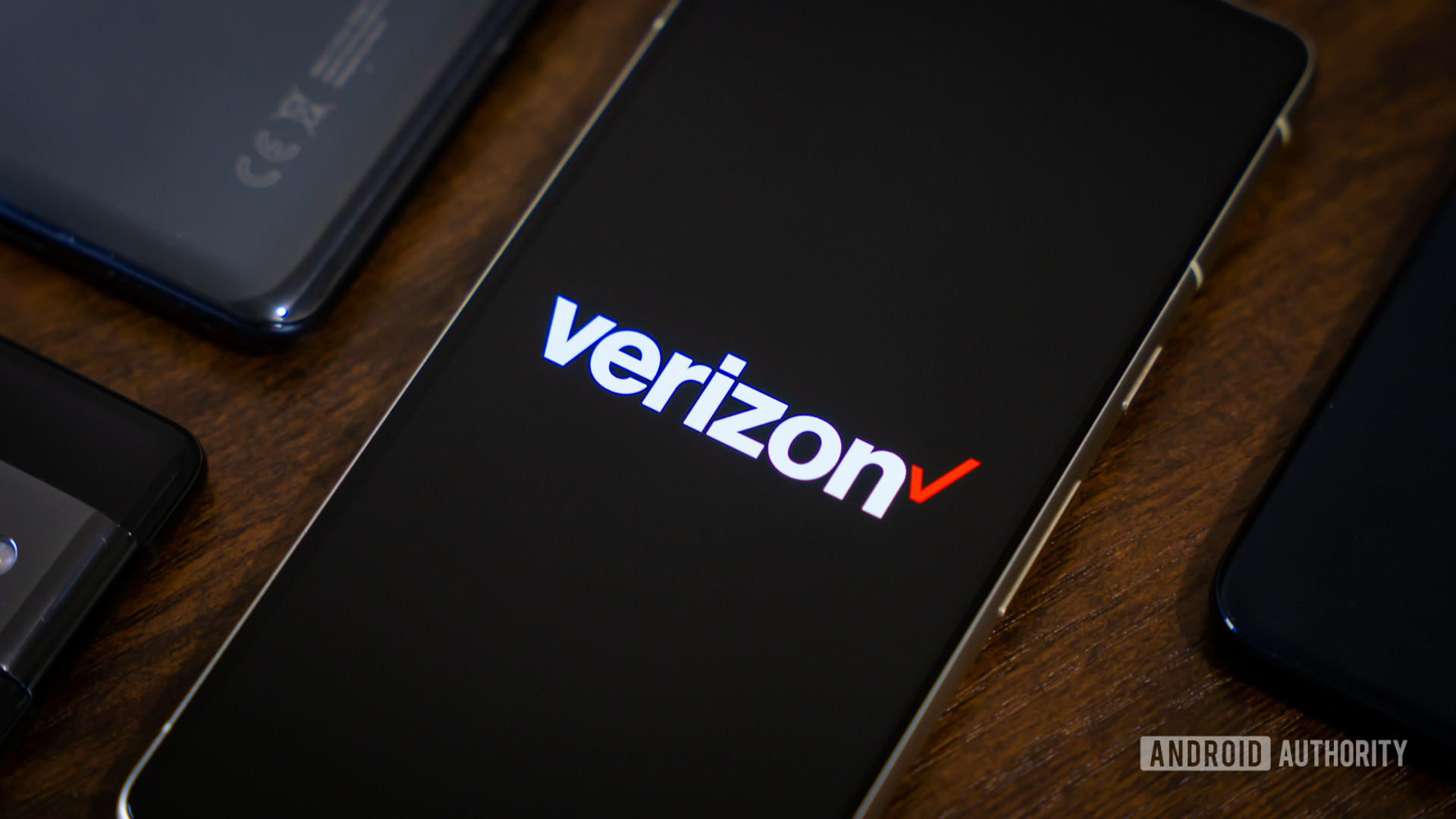 Verizon logo on smartphone, next to other devices (1)