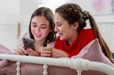 Two smiling girls looking at a phone
